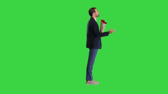 Handsome Man in a Suit Talking To Camera Holding Red Roses on a Green Screen Chroma Key