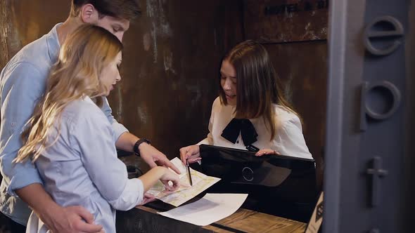 Couple Looking on the Places on Map which Showing for them Smiling Dark hair Female Manage