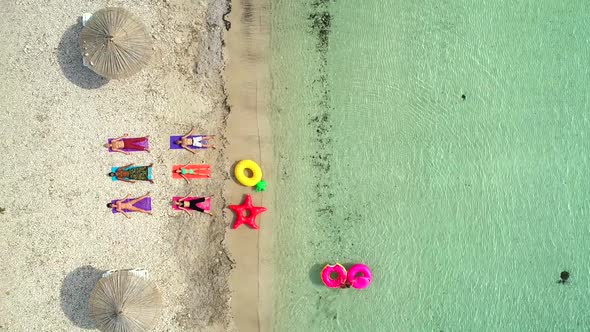 Aerial view of people lying in yoga pose on on the with inflatables.