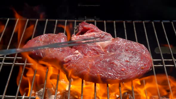 Cook Lays the Steak on the Grill Over an Open Fire