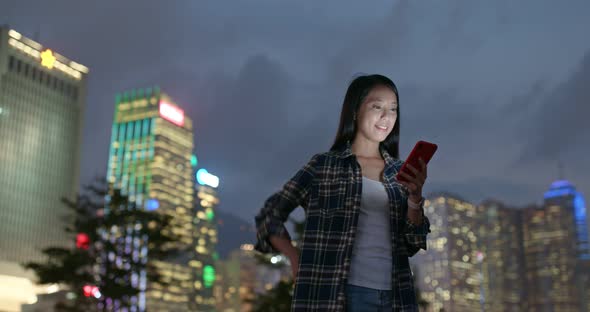 Woman use of mobile phone in city at night