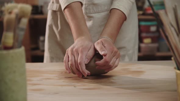 Female Potter Kneads Clay on the Table in Art Studio