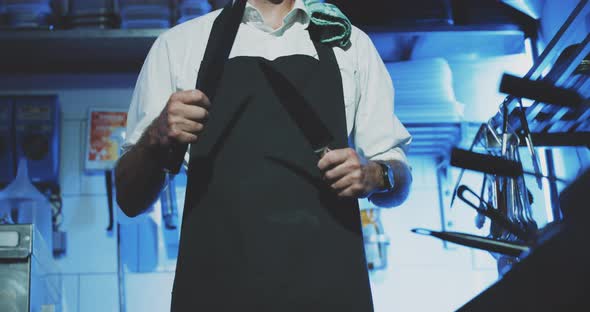 Professional chef sharpening knife in restaurant kitchen close up