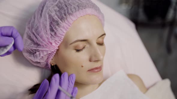 A Beautiful Woman is Lying on the Couch in the Office of a Beautician on the Botox Procedure