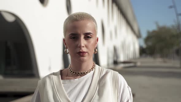 Portrait of Young Serious Woman with Blond Shaved Hair Looking at Camera