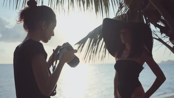 Photographer Takes Aim of Silhouetted Model in Black Sunhat at Beach