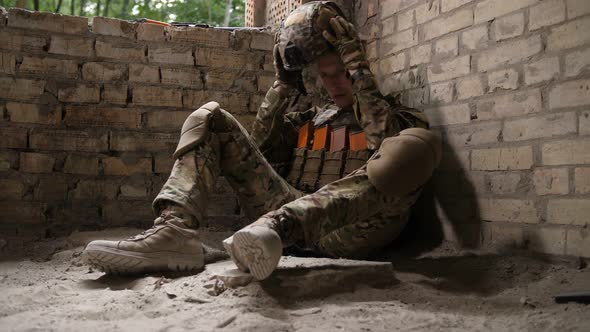 Tired After Battle Army Soldier Sitting on Ground