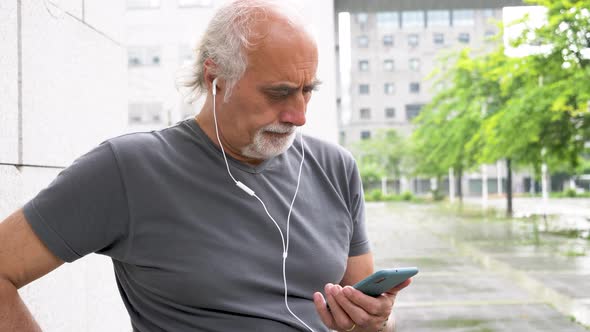 Senior athletic man using smartphone