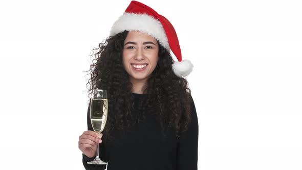 Portrait of Pretty Woman Being Happy While Celebrating New Year Wearing Santa Claus Red Hat Drinking