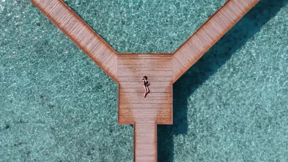 Drone Top View with a woman laying on a platform