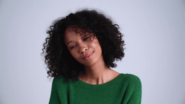 Pleased curly-haired woman dancing