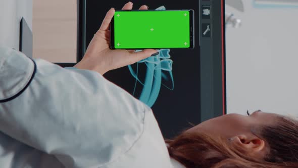 Vertical Video Dentist Vertically Holding Smartphone with Green Screen
