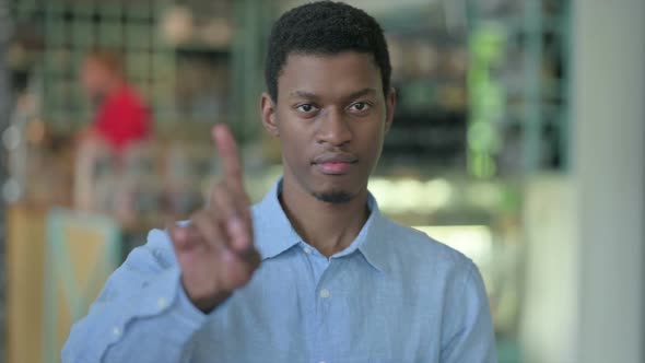 Portrait of Young African Man Saying No with Finger Sign