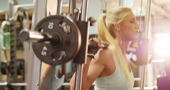 Fit woman exercising with smith machine