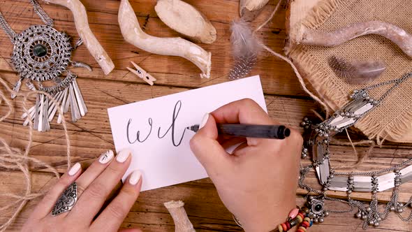 Hand Writing WILD SOUL card on a wooden table top view