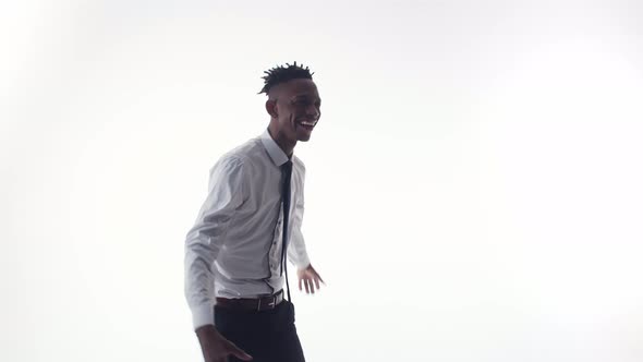 Black Man Happy and Dances in a Suit on White Background