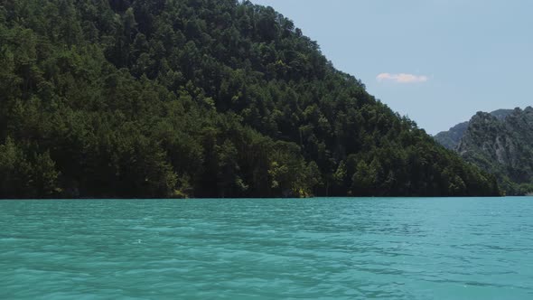 Turquoise Water in a Mountain Forest Lake with Pine Trees