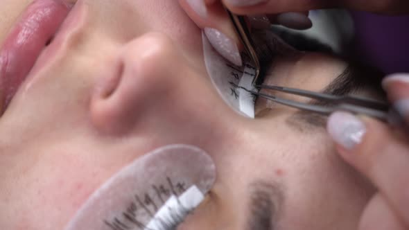Eyelash Extension Master Performs Gluing Eyelashes Closeup