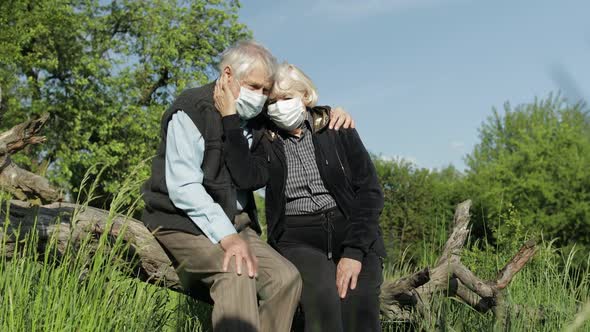 Senior Couple in Medical Masks During COVID-19 Coronavirus Quarantine in Park