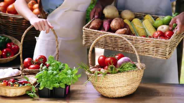 Happy couple holding fresh vegetables in basket