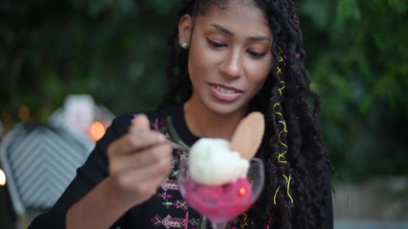 Afro latina woman eating ice cream in restaurant