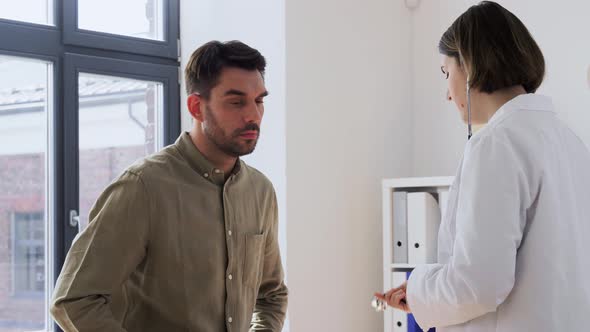 Doctor with Stethoscope and Man at Hospital