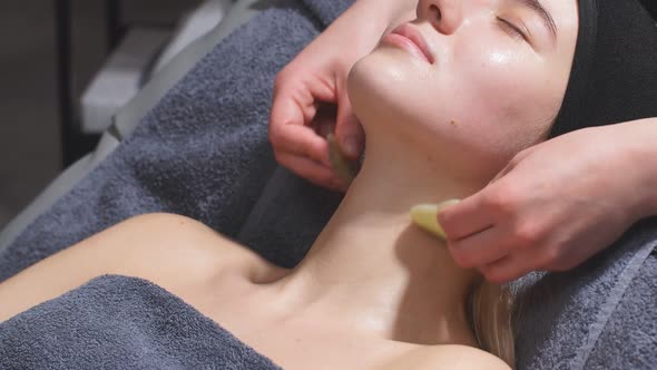 Professional Cosmetologist Uses Quartz Massage Tool Gua Sha To Tighten the Skin of the Face