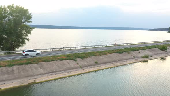 Aerial Shot of Car Rides Through Road Near Lake