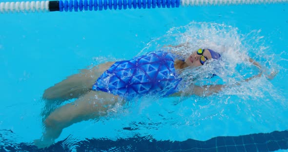 Young female swimmer swimming inside pool 4k