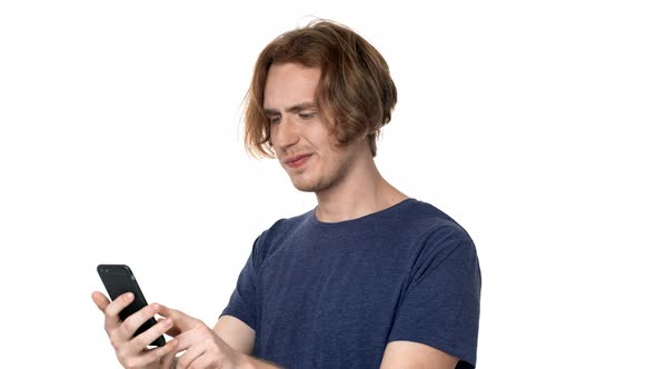 Portrait of Hipster Guy in Casual Tshirt Browsing Internet on Smartphone and Finally Finding