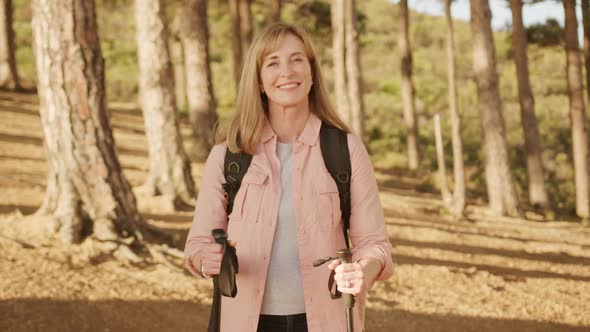 Active senior woman looking at camera in forest