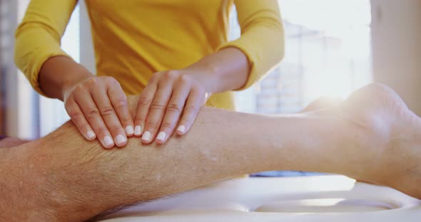 Physiotherapist giving leg massage to a man 4k