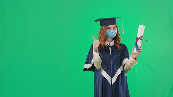 Education in Quarantine Graduate in Academic Clothes and Medical Mask Shows Diploma with Her Finger