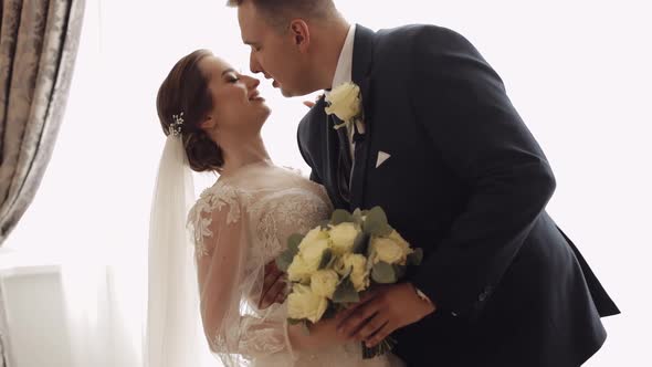 Newlyweds Portrait Caucasian Groom Bride Walking Embracing Hugs in Living Room Wedding Couple
