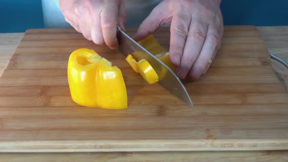 Male Chef Chopping a Fresh Yellow Bell Pepper