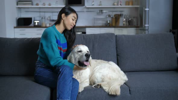 Young Indian Woman Talking To Dog at Home