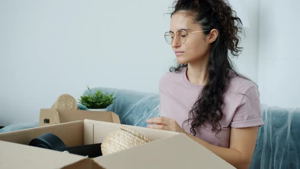 Slow Motion Portrait of Attractive Mixed Race Girl Going Through Personal Stuff Unpacking Box After