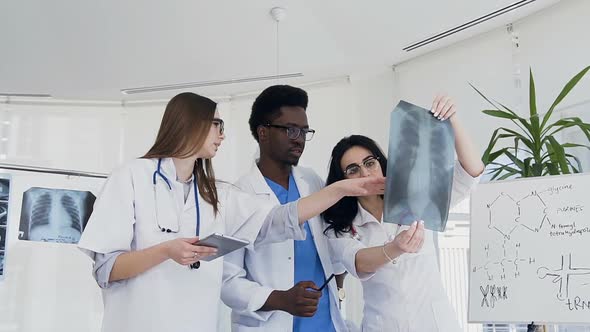 Team of Doctors Researching Lungs xray of ill Patient