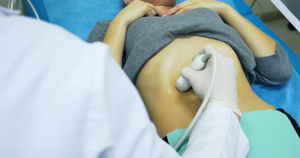 Doctor Making a Ultrasound Diagnostic of Stomach. Looking To Thin Abdomen of Young Women