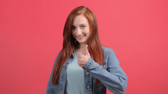 Beautiful Woman Showing Thumbs Up Isolated Over a Red Background