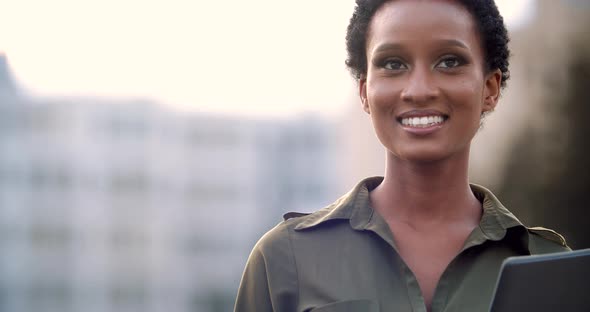 Portrait of Smiling Attractive Interracial Woman in Green Shirt Blouse Standing on Street Holding