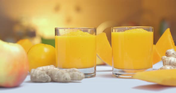 Pumpkin and Ginger Smoothie is Poured Into Glasses Against a Background of Fresh Vegetables and