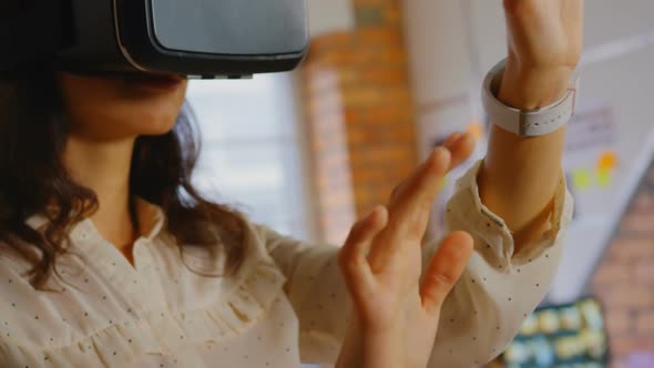Businesswoman trying helmet virtual reality in office.