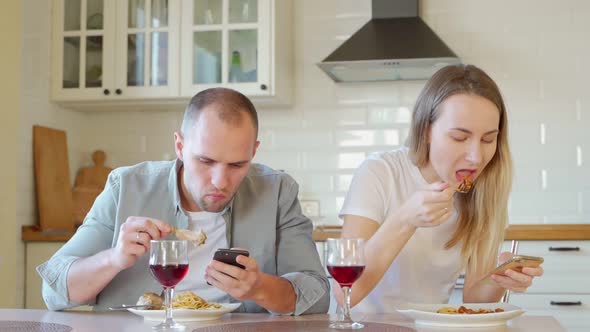 Couple at Breakfast Table Using Mobile Phone