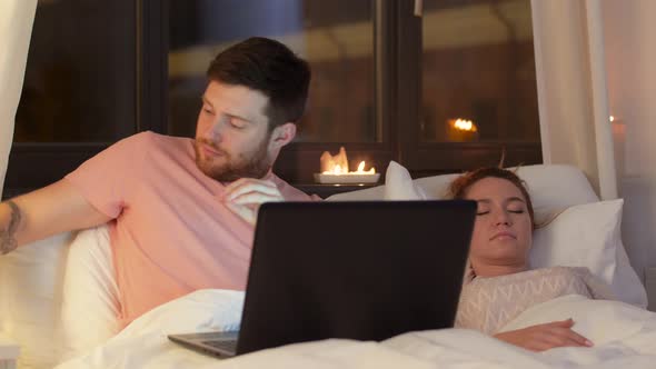 Man in Bed Closing Laptop and Turning Light Off 