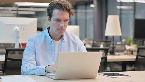 Man Reacting to Loss While Using Laptop