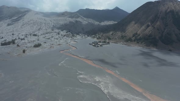 Aerial drone view of volcanic sand and an active volcano