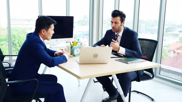 Two Business People Talk Project Strategy at Office