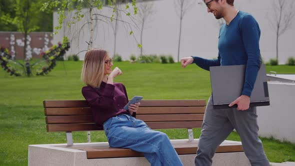 Business colleagues friends greeting each other with Fist-Bumps outdoors smiling happy.