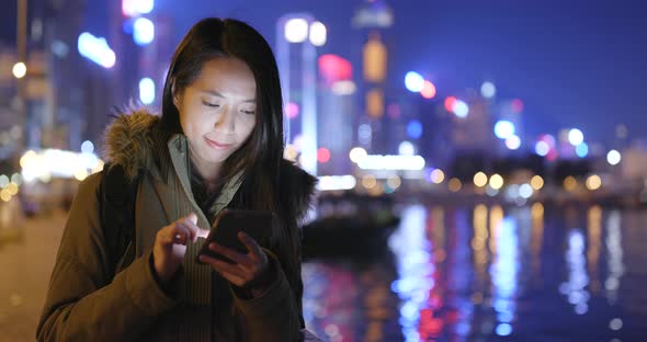 Asian woman use of smart phone in city at night